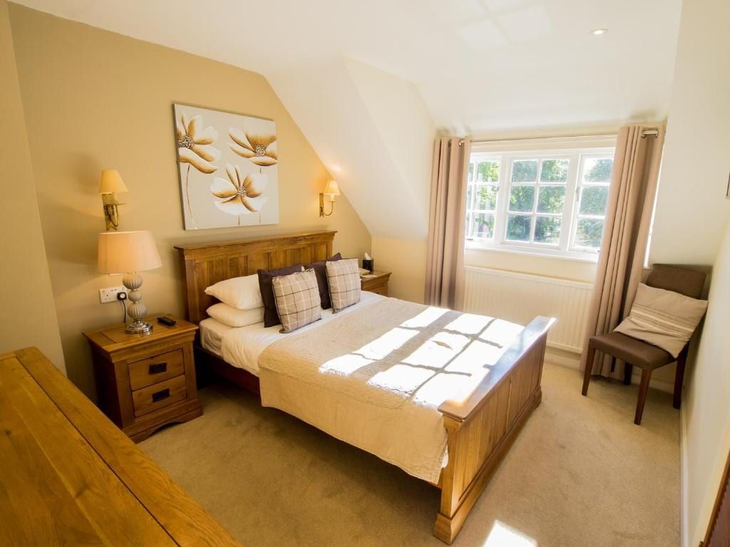 A bedroom with solid oak furniture looking onto the gardens at Sheene Mill