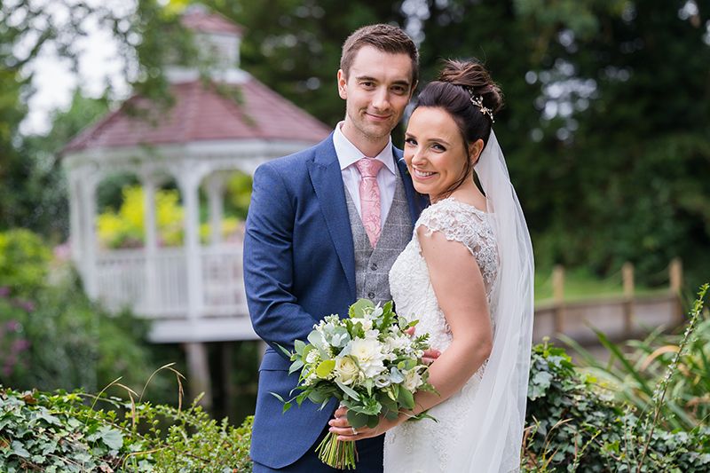 A bride and groom in the gardens by the gazebo at Sheene Mill, Cambridgeshire