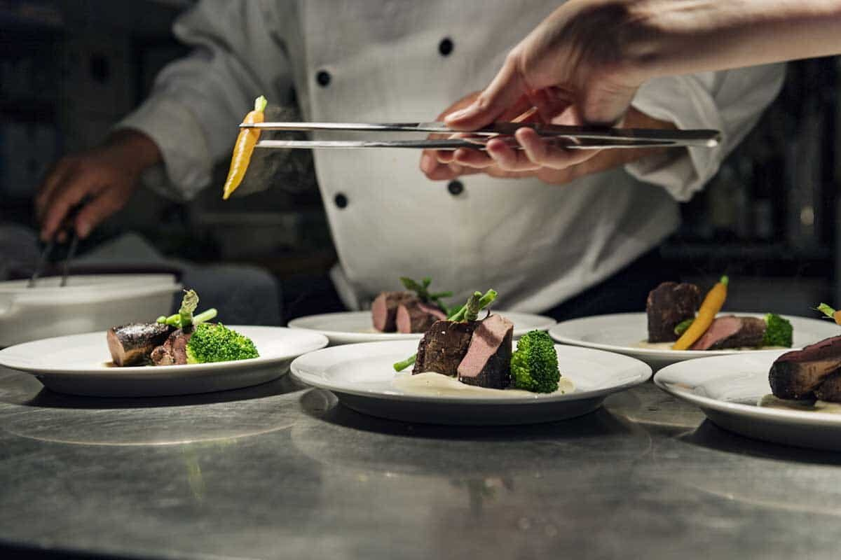 A Sheene Mill chef plating fine dining courses in the kitchen, Melbourn, Cambridgeshire