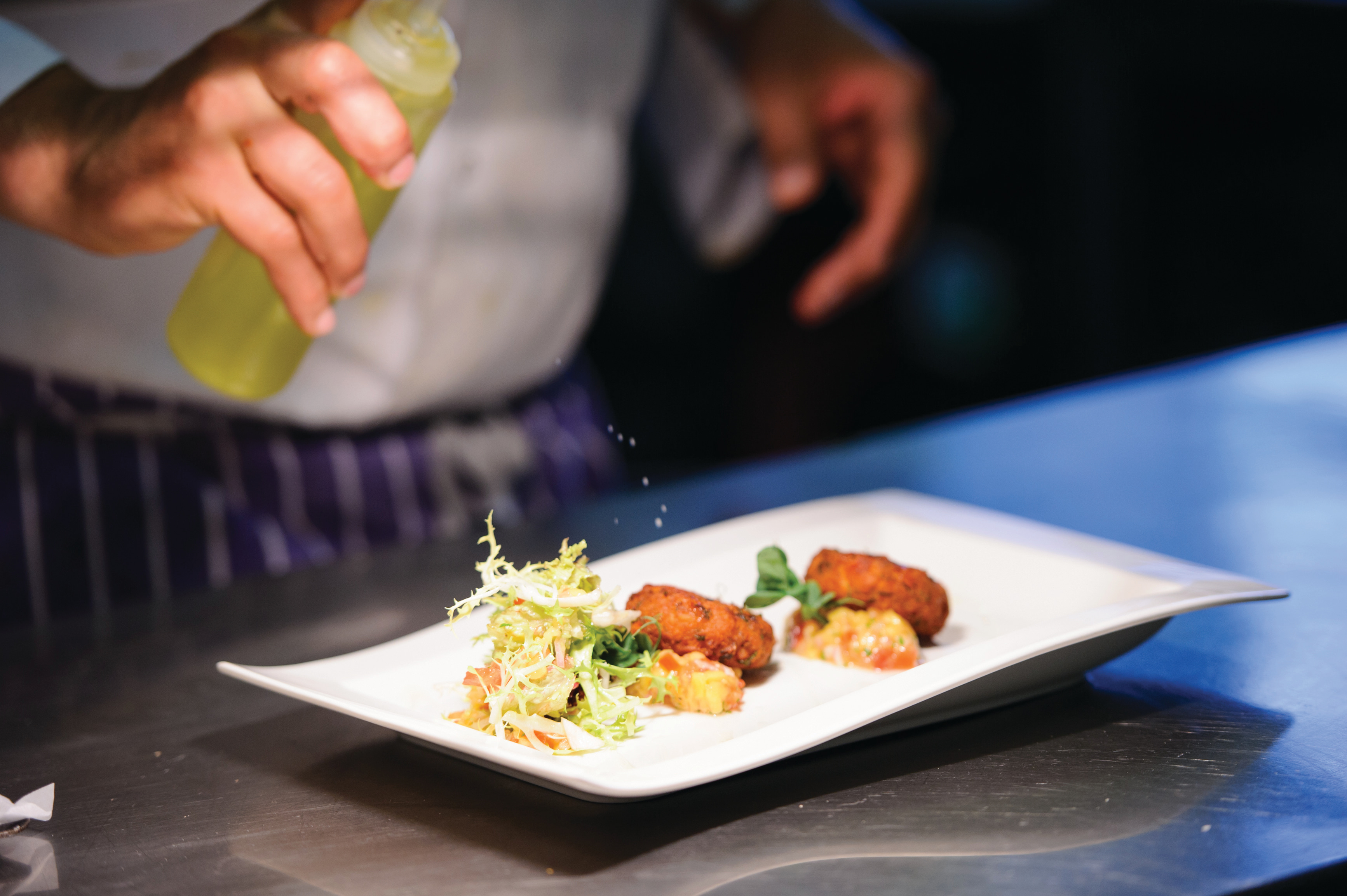 A chef finishing a plated wedding dish in the kitchen at Sheene Mill