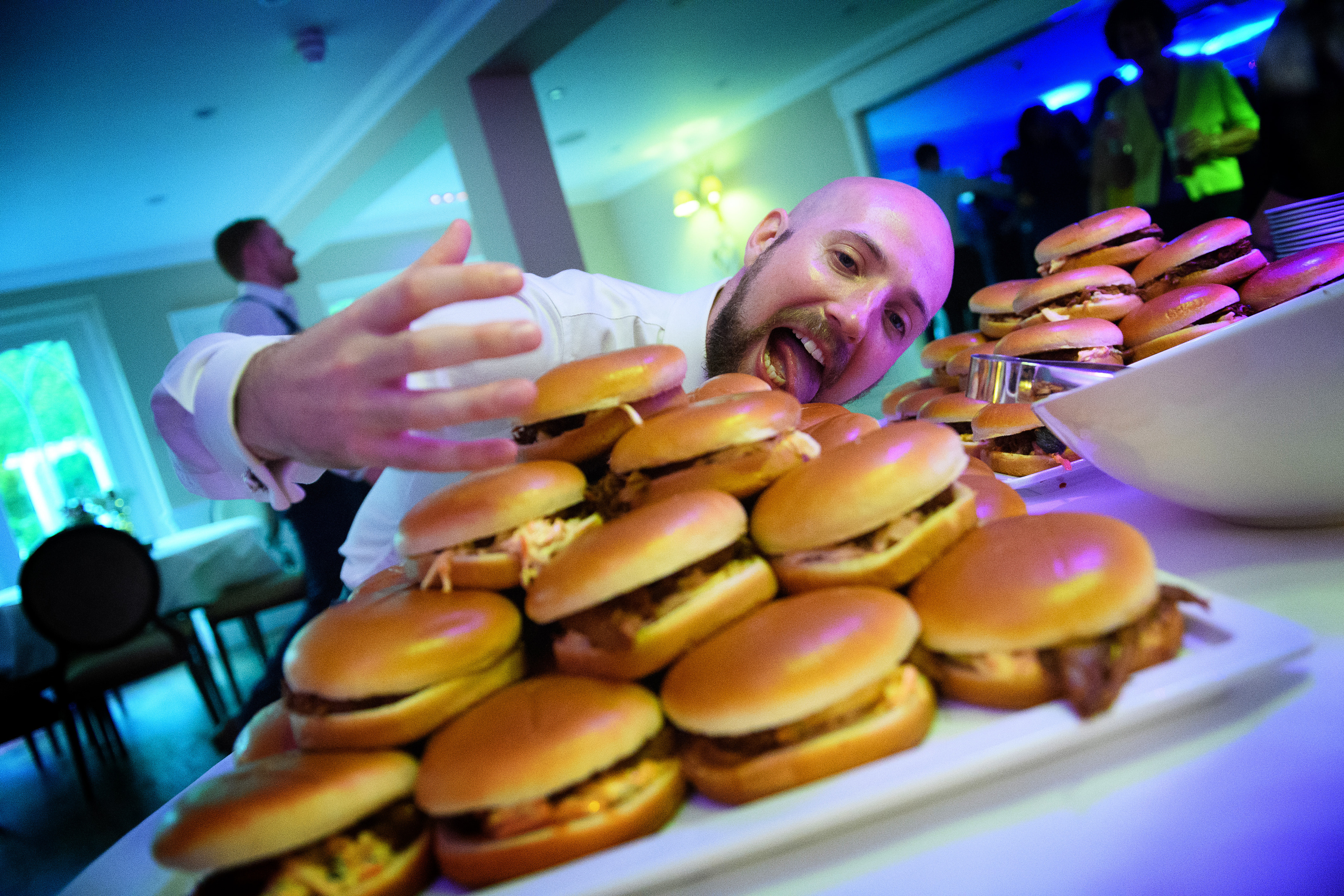 A chef presenting a platter of burgers at an evening party at Sheene Mill