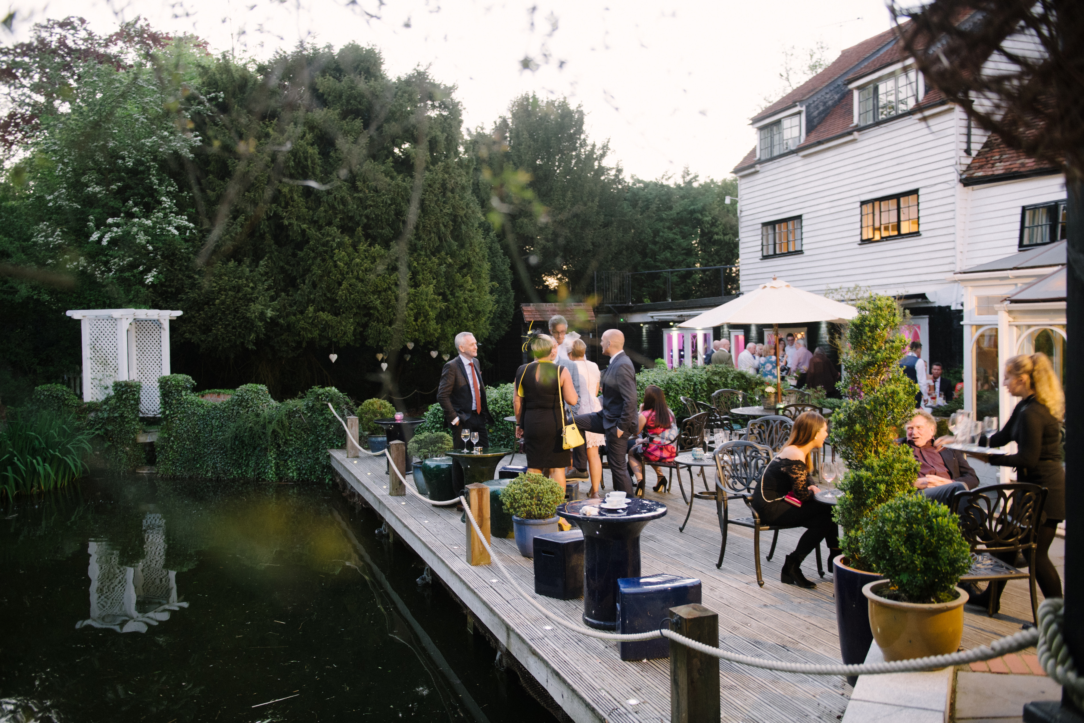 Guests gathered on the riverside terrace beside the mill pond at Sheene Mill