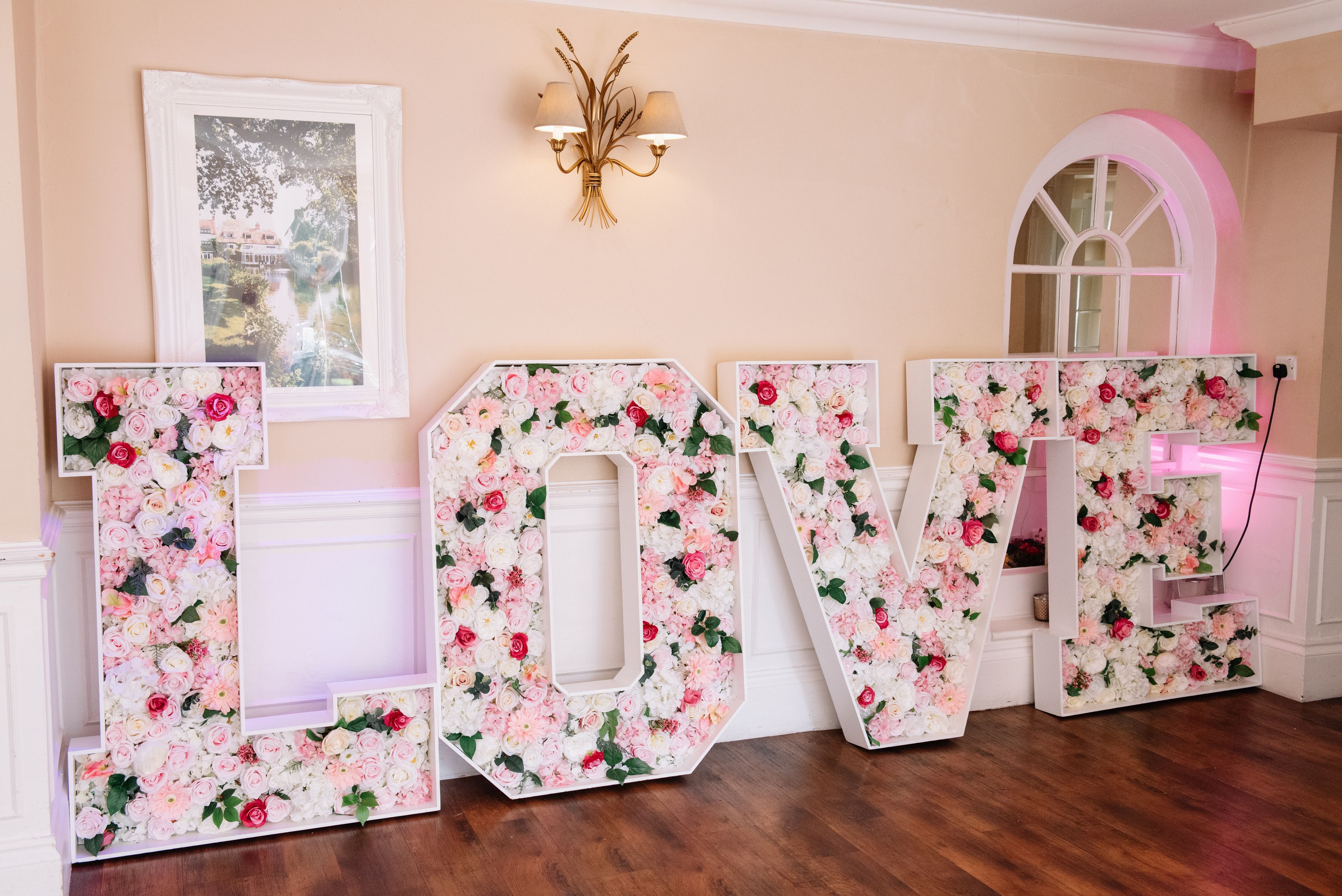 Floral LOVE letters lit up in the reception room at Sheene Mill