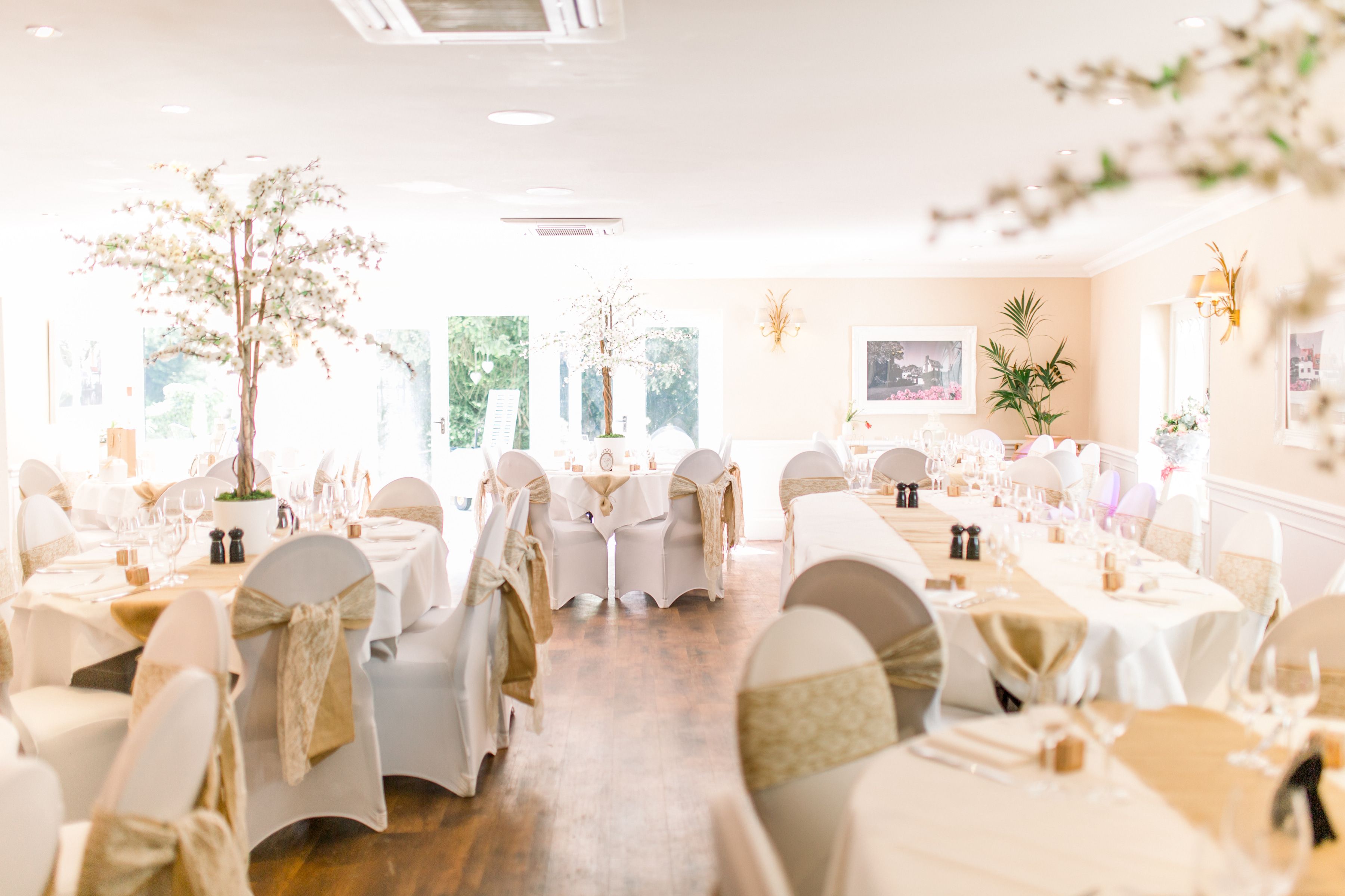 The main banqueting room dressed for a wedding breakfast at Sheene Mill, original beams and elegant interior, Cambridgeshire
