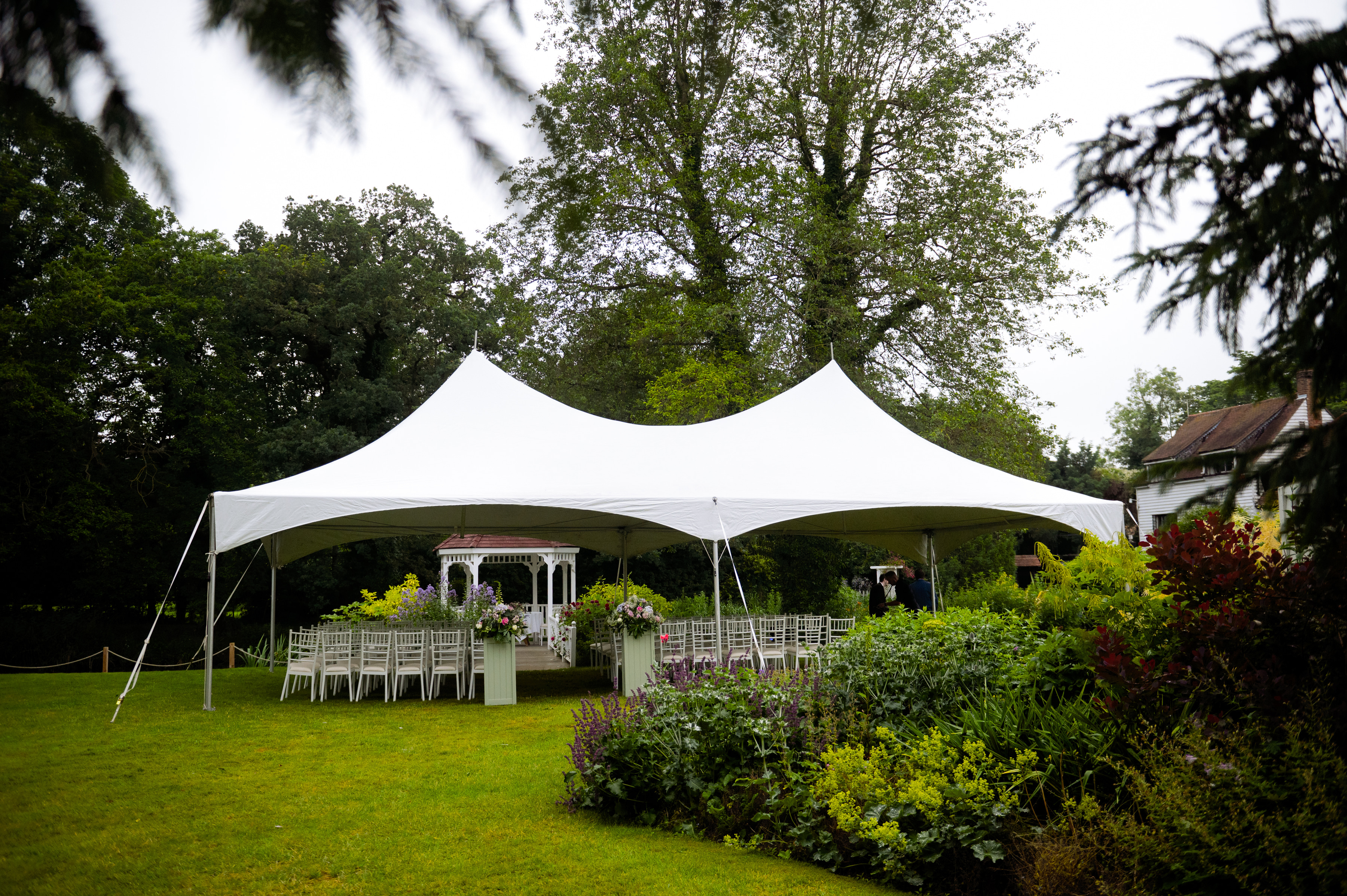 A white marquee on the lawn in the gardens at Sheene Mill