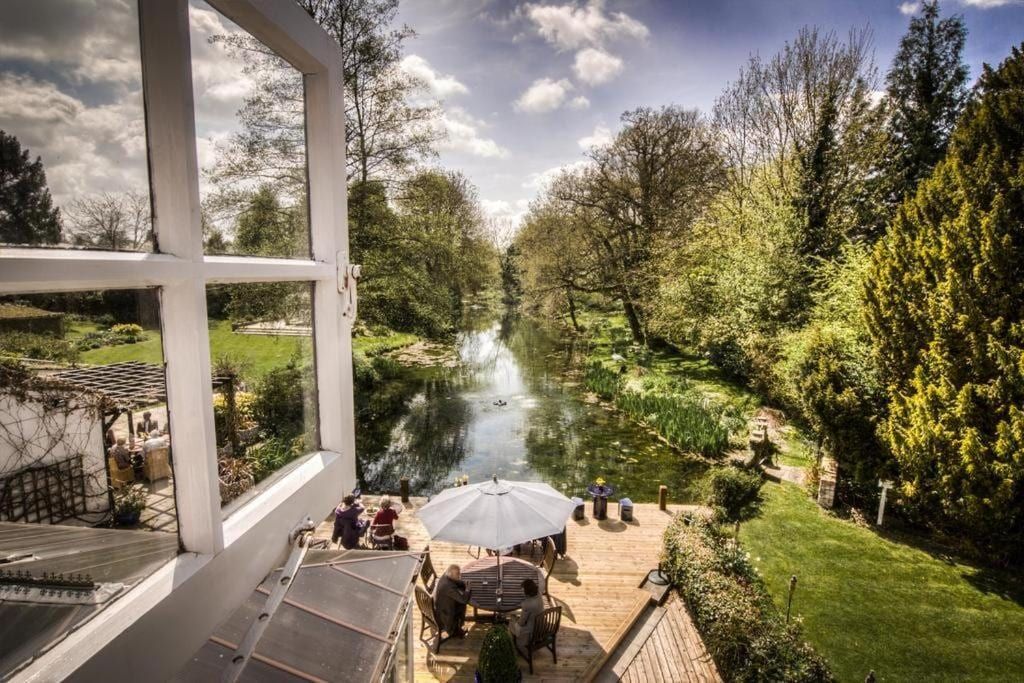 The riverside terrace at Sheene Mill with parasols overlooking the River Mel