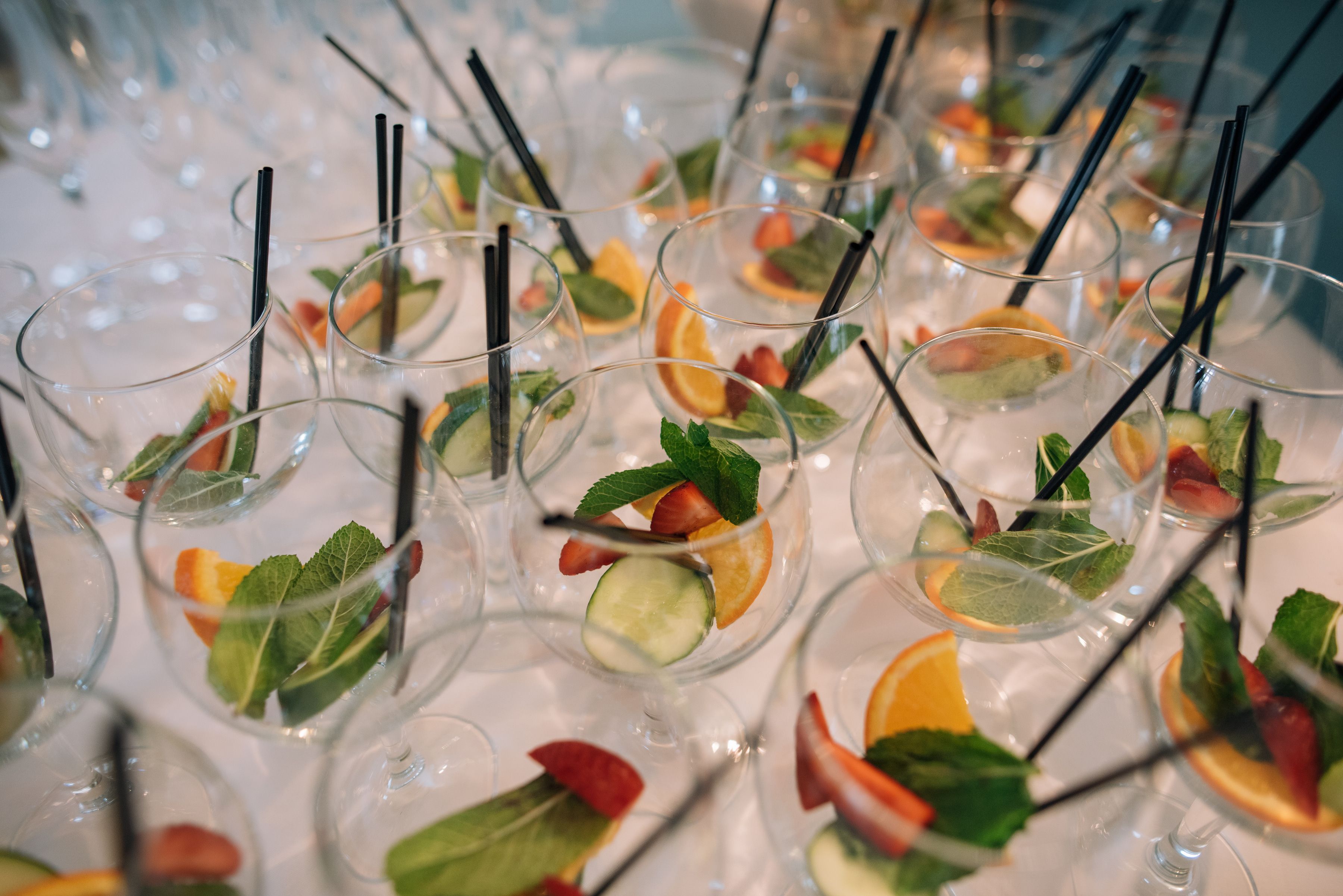 Glasses of fruit cup with mint, orange and cucumber lined up for a drinks reception at Sheene Mill